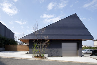 Ejemplo de fachada de casa gris minimalista de tamaño medio a niveles con tejado a cuatro aguas y tejado de metal