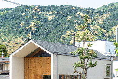 Cette photo montre une façade de maison blanche asiatique à un étage avec un revêtement mixte, un toit à deux pans et un toit en shingle.