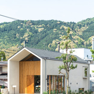 Asian two-storey white house exterior in Kyoto with mixed siding, a gable roof and a shingle roof.