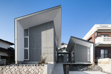 Imagen de fachada gris actual con revestimiento de madera y tejado de un solo tendido