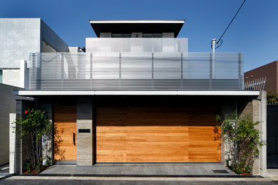 Imagen de fachada gris moderna de tres plantas con tejado plano