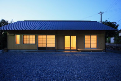 Small asian beige one-story wood exterior home photo in Other with a metal roof