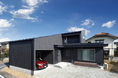 Foto de fachada de casa negra de dos plantas con tejado de un solo tendido y tejado de metal