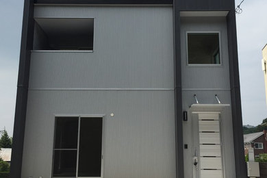 Modelo de fachada de casa gris rústica de dos plantas con revestimientos combinados, tejado plano y tejado de metal