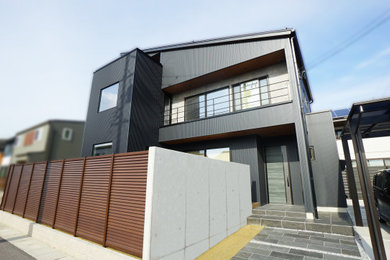 Ejemplo de fachada de casa negra minimalista grande de dos plantas con revestimiento de metal, tejado de un solo tendido y tejado de metal
