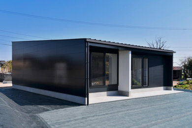 Black bungalow detached house in Other with a metal roof.