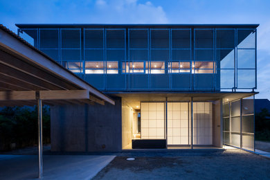 Foto de fachada de casa gris minimalista de dos plantas con revestimiento de hormigón, tejado a cuatro aguas y tejado de metal