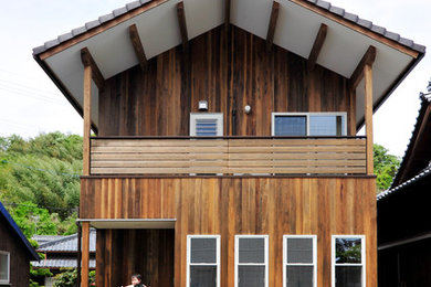 Modelo de fachada de casa marrón de estilo de casa de campo de dos plantas con revestimiento de madera y tejado de teja de barro
