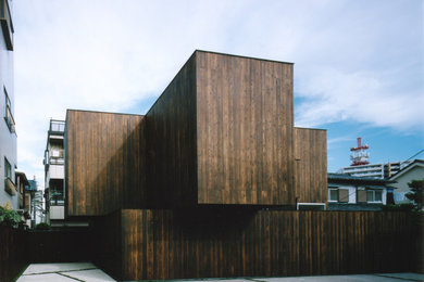Foto de fachada de casa marrón minimalista de tamaño medio de dos plantas con revestimiento de madera, tejado de un solo tendido y tejado de metal