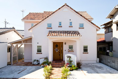 Foto de fachada de casa blanca mediterránea de dos plantas con revestimiento de estuco y tejado de teja de barro