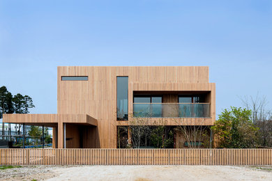 Imagen de fachada de casa beige nórdica de dos plantas con revestimiento de madera, tejado de teja de madera y tejado a dos aguas