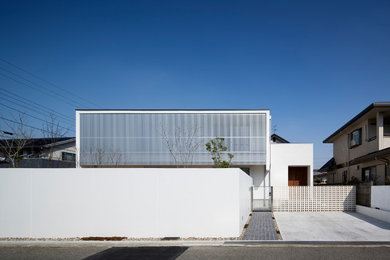 Ejemplo de fachada blanca minimalista de dos plantas con tejado plano