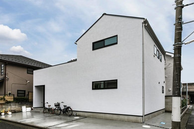 Example of an urban white two-story exterior home design in Tokyo with a metal roof