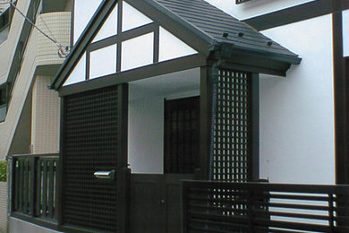 This is an example of a white world-inspired two floor render detached house in Tokyo with a pitched roof and a tiled roof.
