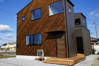 Diseño de fachada de casa marrón moderna de tamaño medio de dos plantas con revestimiento de madera