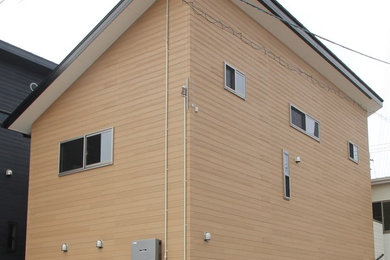 Cette image montre une façade de maison beige minimaliste à un étage avec un revêtement mixte, un toit en appentis et un toit en métal.