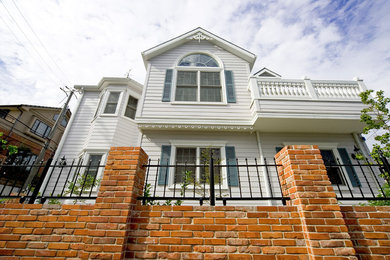 Foto de fachada de casa blanca clásica de tamaño medio de dos plantas con revestimientos combinados