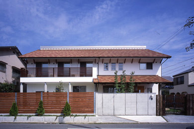 Foto de fachada de casa blanca grande de dos plantas con tejado a dos aguas y tejado de teja de barro