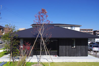 Foto de fachada negra asiática pequeña de una planta con revestimiento de madera y tejado a cuatro aguas