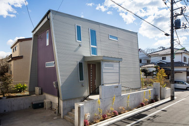 Imagen de fachada de casa morado moderna de tamaño medio de dos plantas con revestimiento de metal, tejado de un solo tendido y tejado de metal