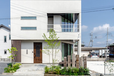 Esempio della facciata di una casa bianca moderna a due piani di medie dimensioni con rivestimenti misti e copertura in metallo o lamiera