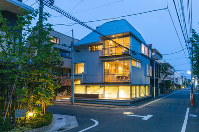 Diseño de fachada de casa gris minimalista de dos plantas con revestimientos combinados, tejado a cuatro aguas y tejado de metal