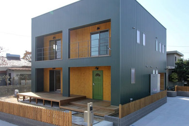 Foto de fachada de casa verde urbana grande de dos plantas con revestimiento de metal, tejado plano y tejado de metal