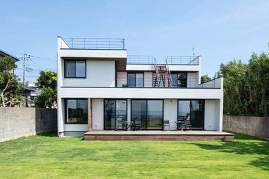 Exemple d'une grande façade de maison blanche moderne à un étage avec un toit plat.