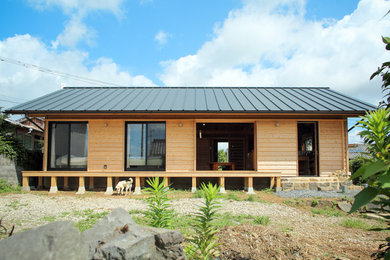 Imagen de fachada de casa marrón de estilo zen con revestimiento de madera y tejado a dos aguas