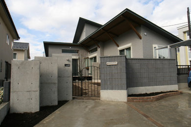 Réalisation d'une façade de maison grise à un étage.
