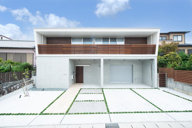 Ejemplo de fachada de casa blanca moderna de dos plantas con revestimiento de hormigón, tejado de un solo tendido y tejado de metal