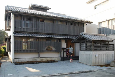 Aménagement d'une façade de maison blanche asiatique en stuc à un étage avec un toit à deux pans.