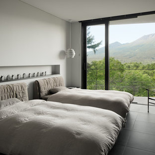 Immagine di una camera da letto minimalista con pareti bianche e pavimento nero