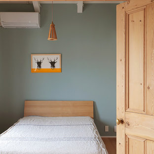 Skandinavisches Schlafzimmer mit grüner Wandfarbe, braunem Holzboden und braunem Boden in Tokio Peripherie