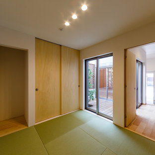 Diseño de habitación de invitados minimalista con paredes blancas, tatami y suelo verde