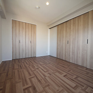 Foto de habitación de invitados industrial con paredes beige, suelo de contrachapado y suelo marrón