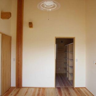 Ejemplo de dormitorio asiático, grande, con suelo de madera clara y suelo verde