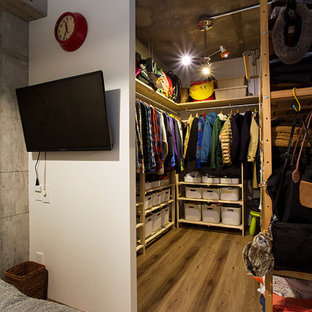 Diseño de dormitorio principal, industrial, pequeño, sin chimenea, con paredes blancas, suelo de contrachapado y suelo marrón