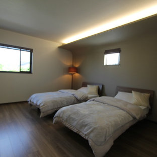 Ejemplo de dormitorio principal, rural, de tamaño medio, con paredes grises, suelo de contrachapado y suelo marrón