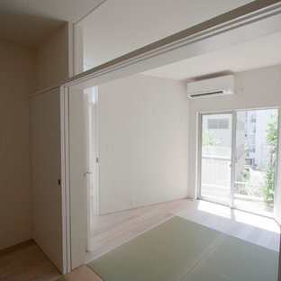 Imagen de habitación de invitados moderna, pequeña, con paredes blancas y suelo verde