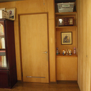 Ejemplo de habitación de invitados moderna con suelo de contrachapado