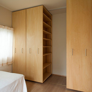 Diseño de dormitorio principal, de estilo de casa de campo, de tamaño medio, con paredes blancas, suelo de contrachapado, chimeneas suspendidas y suelo beige