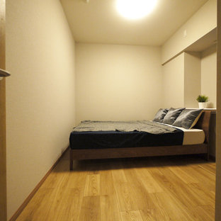 Diseño de dormitorio principal, moderno, con paredes beige, suelo de contrachapado y suelo marrón