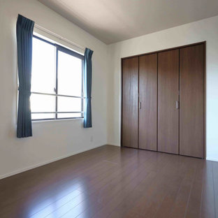Esempio di una camera da letto minimalista con pareti bianche, pavimento in compensato, pavimento marrone e carta da parati