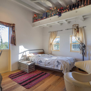 Imagen de dormitorio principal, mediterráneo, pequeño, sin chimenea, con paredes blancas y suelo de madera en tonos medios