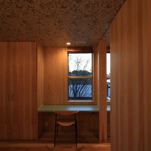 Modelo de dormitorio principal, nórdico, de tamaño medio, con paredes beige, suelo de madera en tonos medios, estufa de leña, marco de chimenea de hormigón y suelo beige