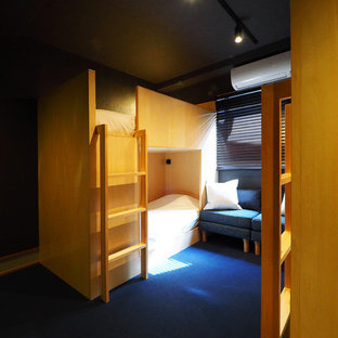 Ejemplo de dormitorio tipo loft, de estilo zen, sin chimenea, con paredes negras, moqueta y suelo azul