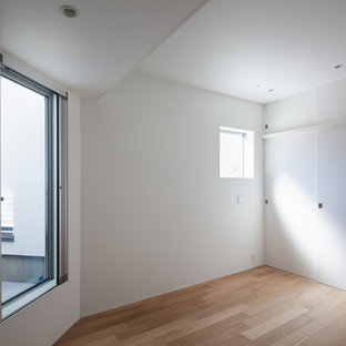 Kleines Modernes Hauptschlafzimmer ohne Kamin mit weißer Wandfarbe, Sperrholzboden und braunem Boden in Tokio