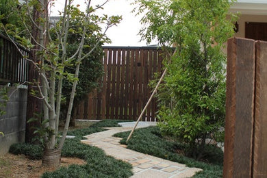 他の地域にあるコンテンポラリースタイルのおしゃれな庭 (庭への小道、天然石敷き) の写真
