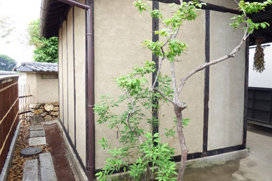 Imagen de jardín asiático grande en primavera en patio delantero con muro de contención y exposición reducida al sol